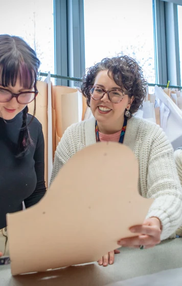 Fashion students collaborating on a sewing project under the guidance of their lecturer. Fashion students collaborating on a sewing project under the guidance of their lecturer.